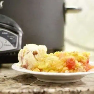 dump cake on a plate in front of a crock pot