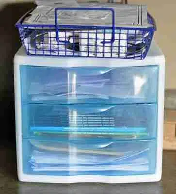 blue plastic drawer organizer, wire bin on top.