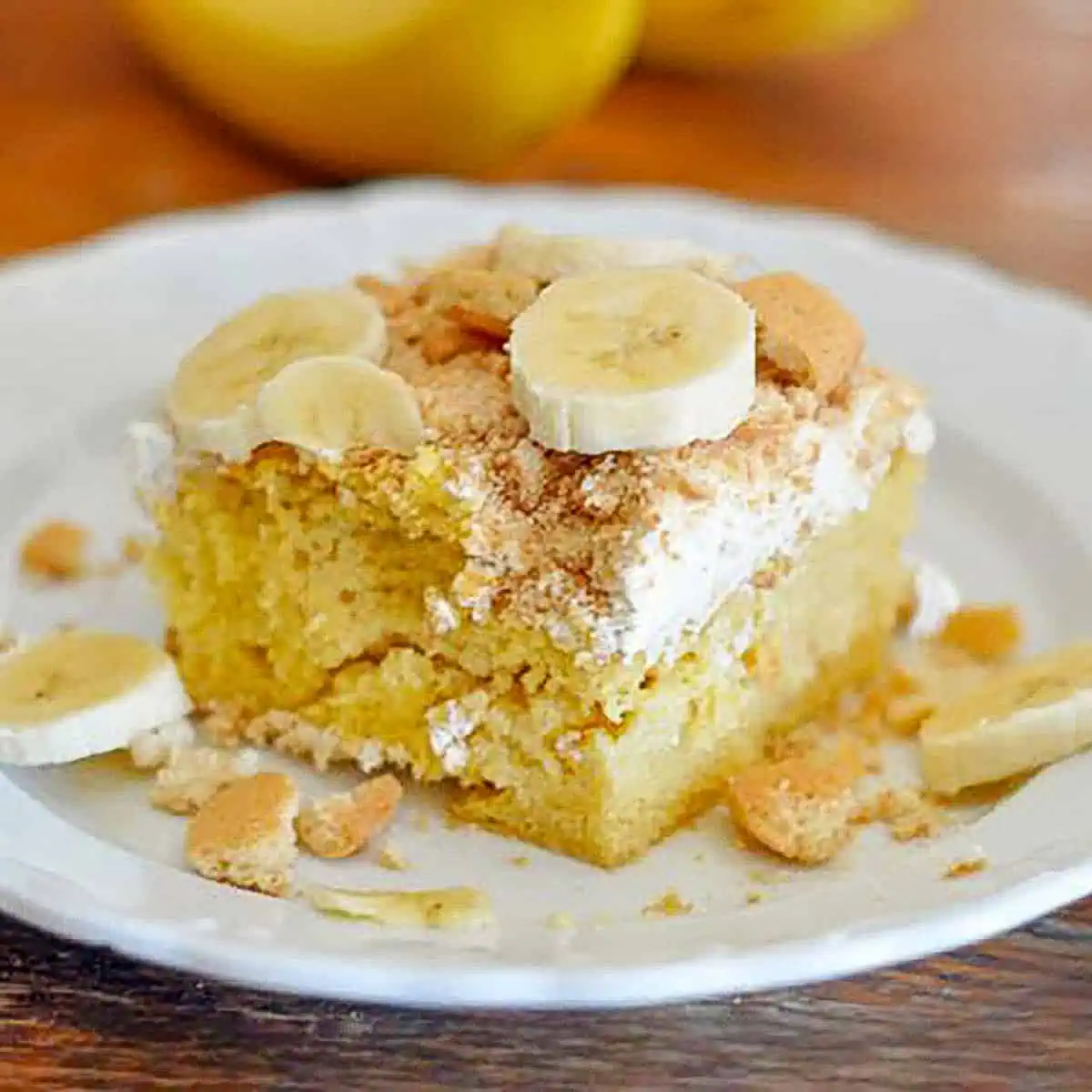 banana pudding poke cake on a white plate on a table.