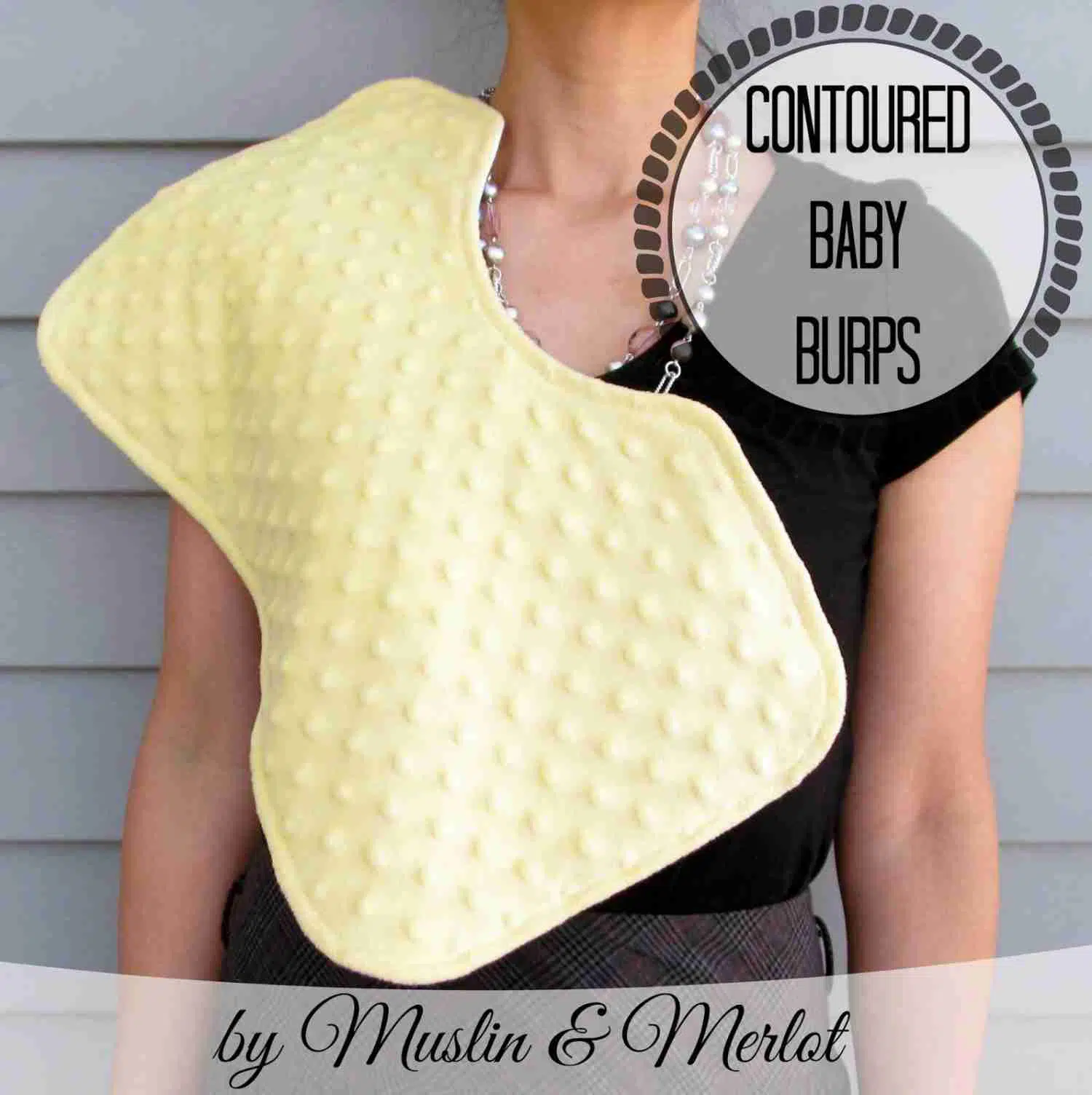yellow contoured baby burp on a woman\'s shoulder.