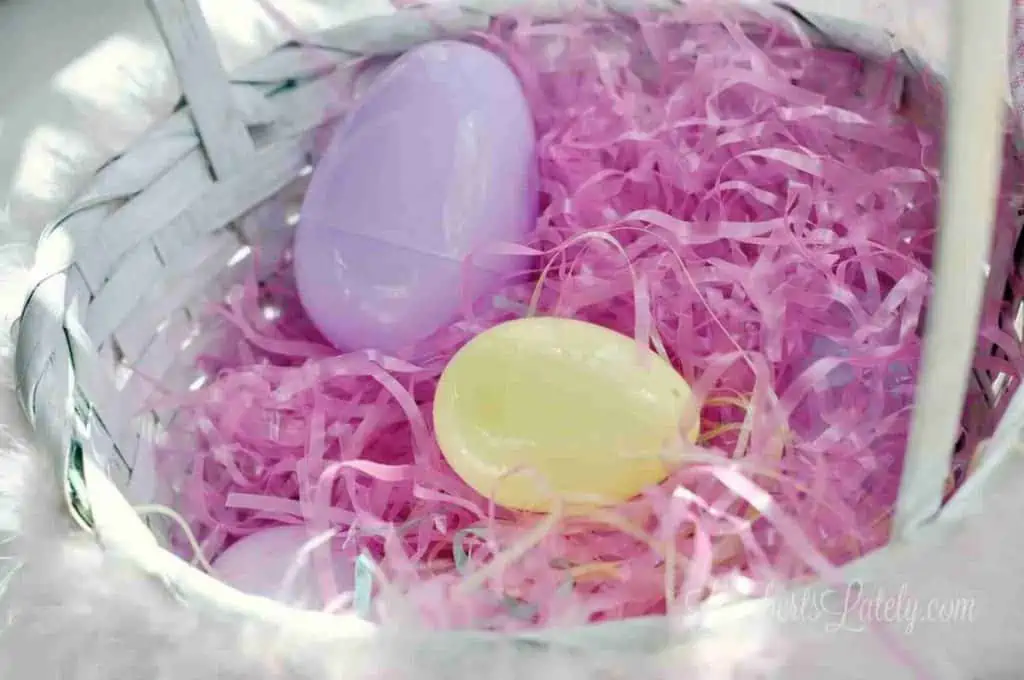 plastic easter eggs in pink easter grass in a basket.