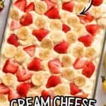 Strawberry banana poke cake topped with fresh strawberries and bananas.
