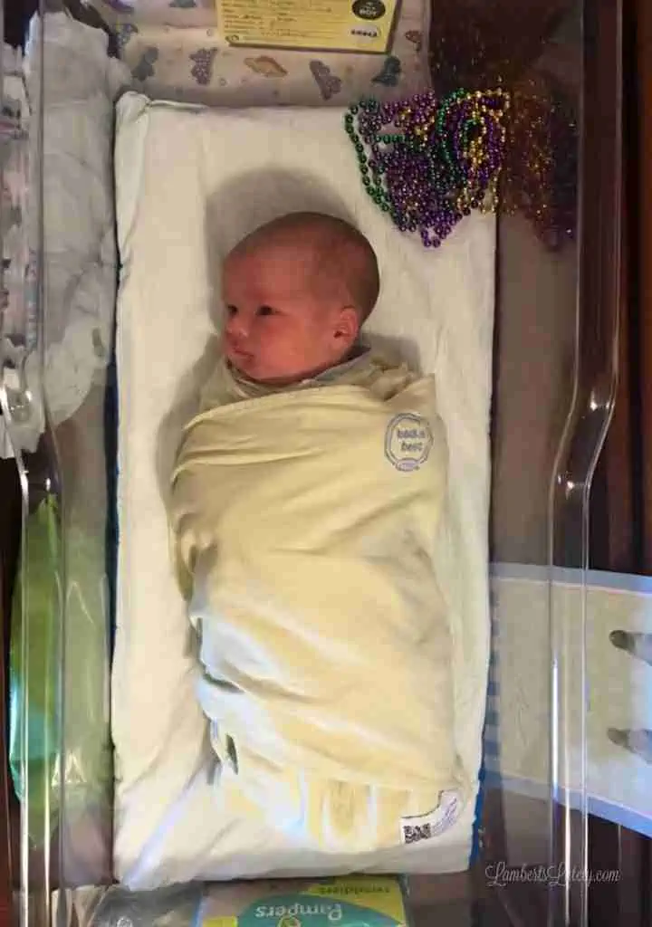 newborn in a bassinet, with beads beside him.