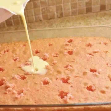 pouring banana pudding mix over a strawberry cake.