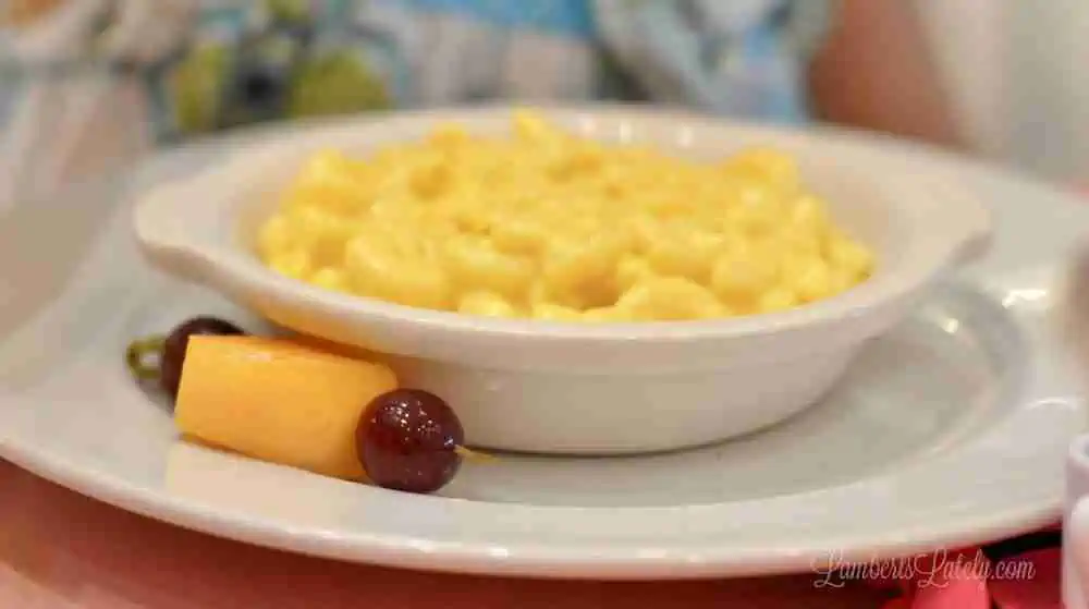 bowl of macaroni and cheese with fruit on the side.