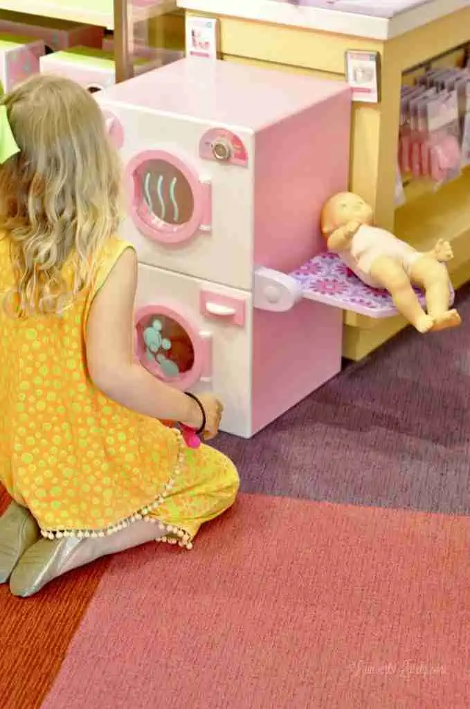 child playing with toy washer and dryer.