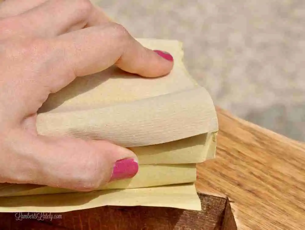 sanding wood with sandpaper on a block.