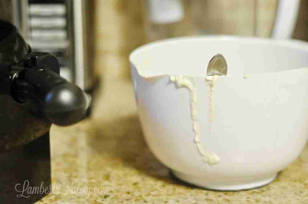 white bowl of pancake batter with spoon in it on a counter.