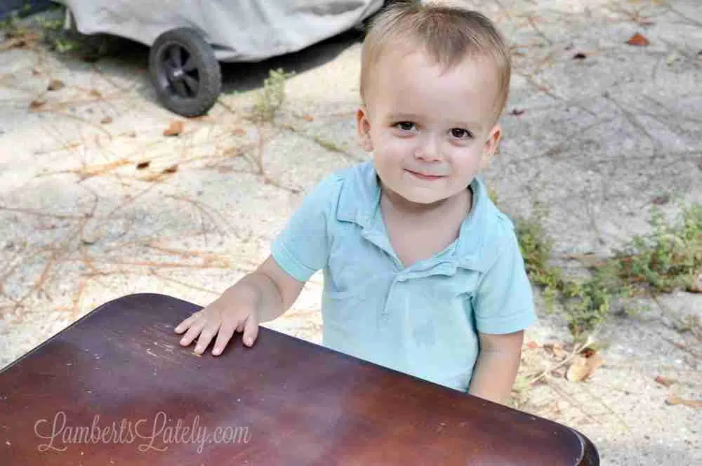 little boy behind a table.