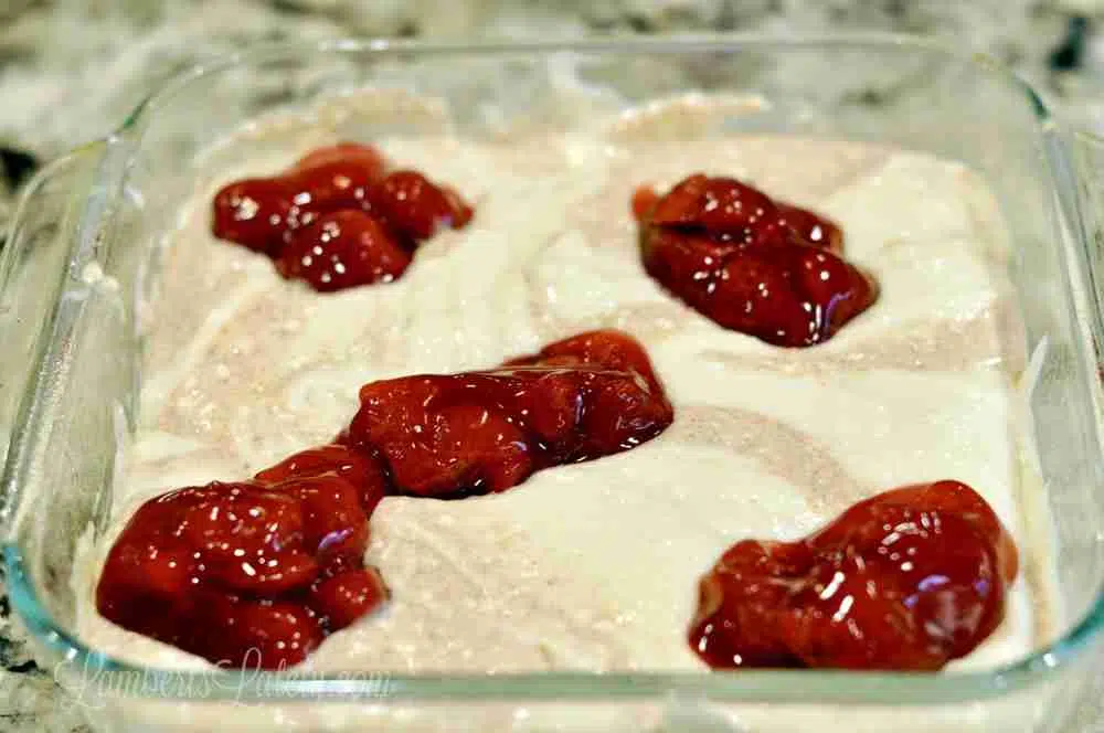 strawberry pie filling spooned over batter.