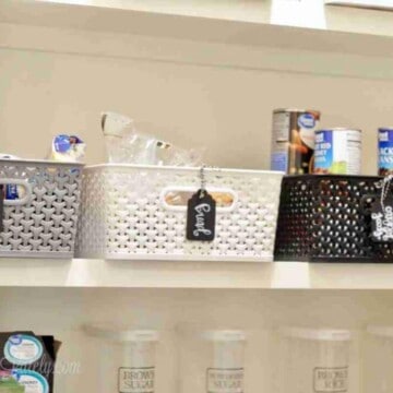 baskets and clear canisters on a pantry shelf.