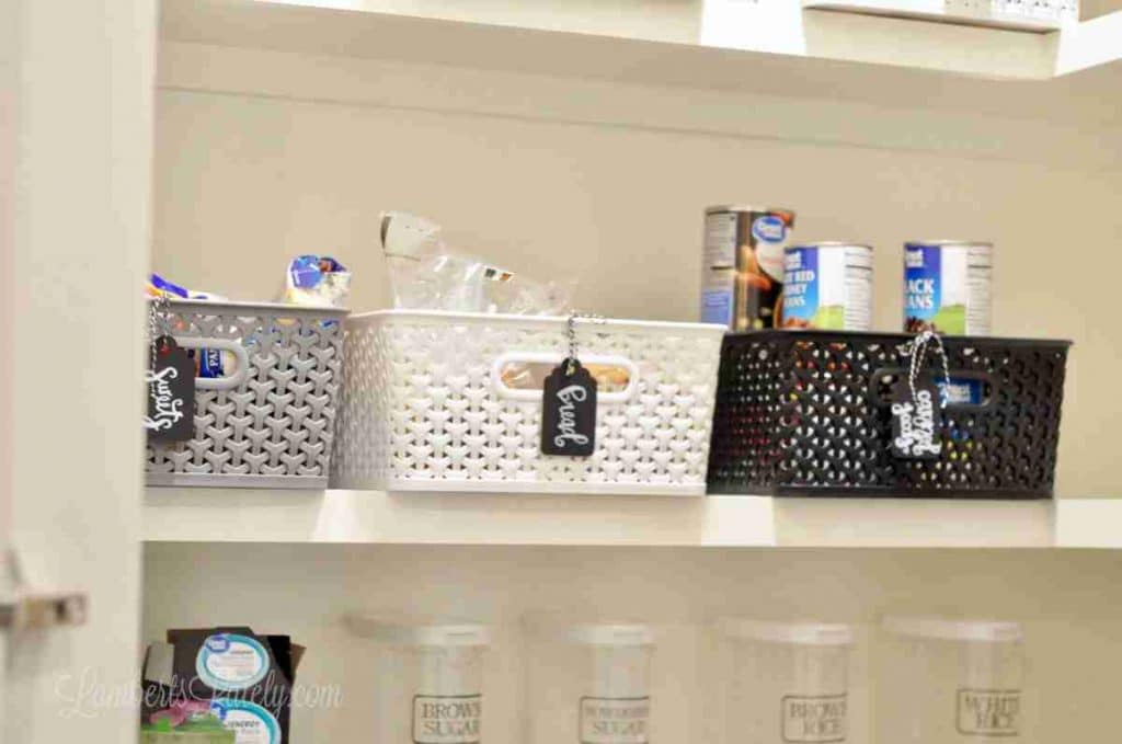 baskets and clear canisters on a pantry shelf.