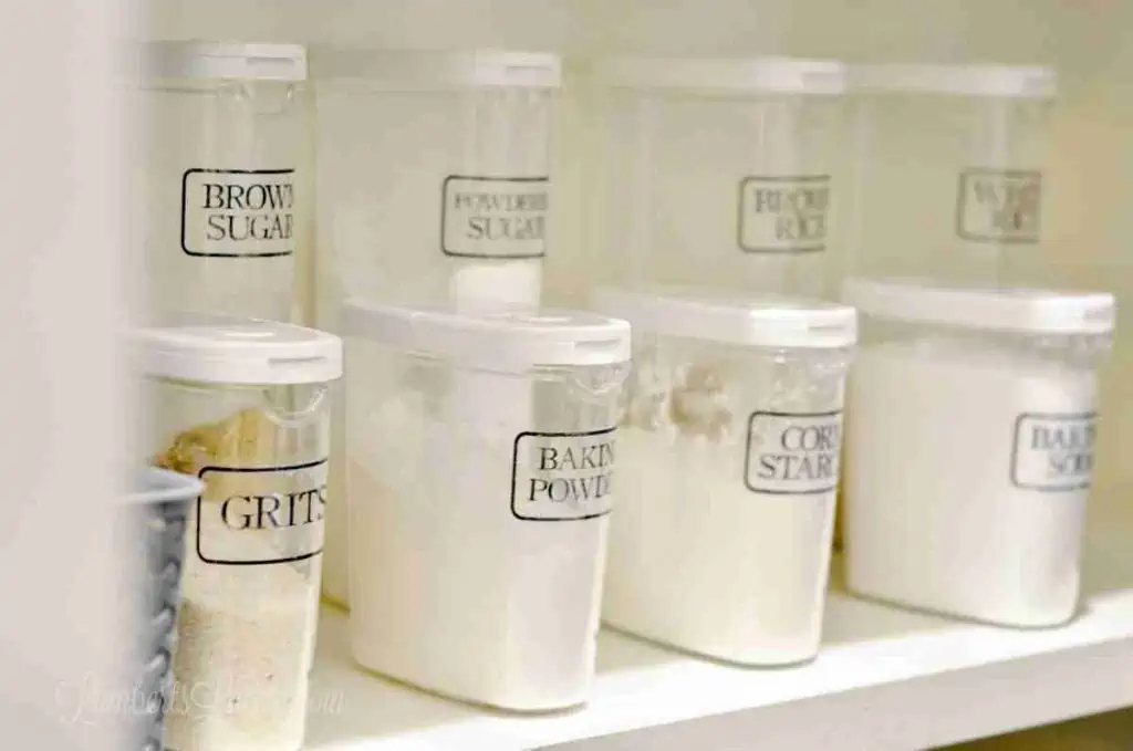 clear labeled canisters on a pantry shelf.