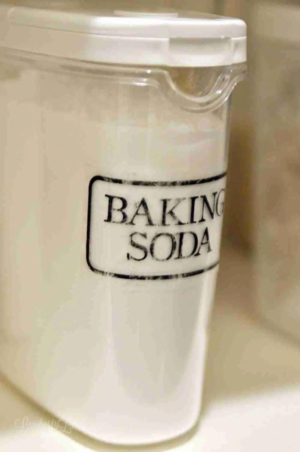 close up of clear canister with baking soda label on front.