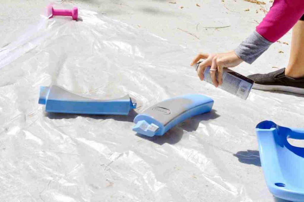 spray painting top parts of a cozy coupe.