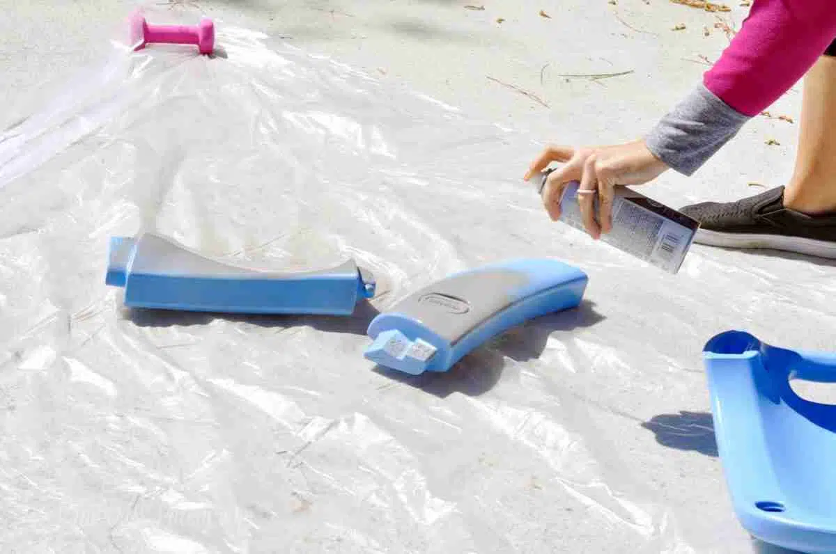 spray painting top parts of a cozy coupe.