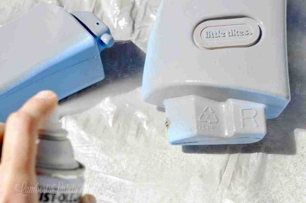 spray painting top parts of a cozy coupe.