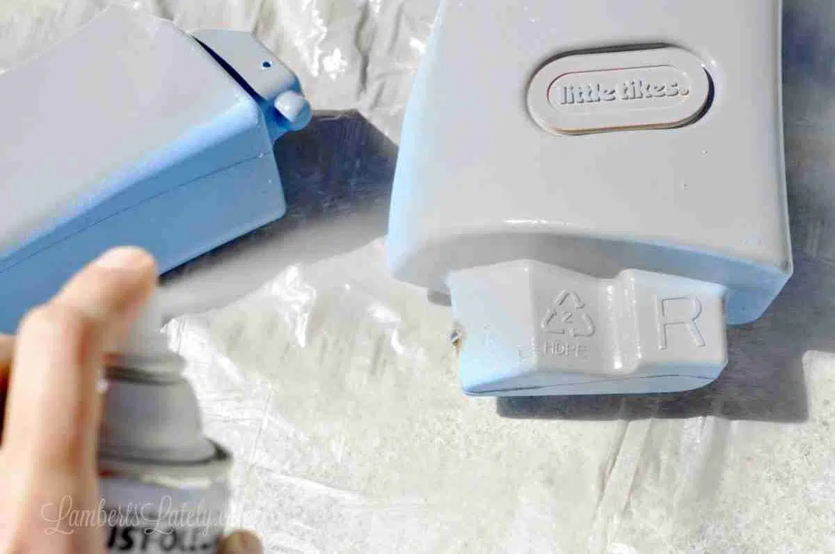 spray painting top parts of a cozy coupe.