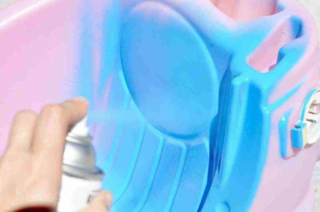 painting a cozy coupe inside with spray paint.