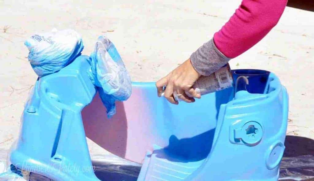 painting a cozy coupe with spray paint.