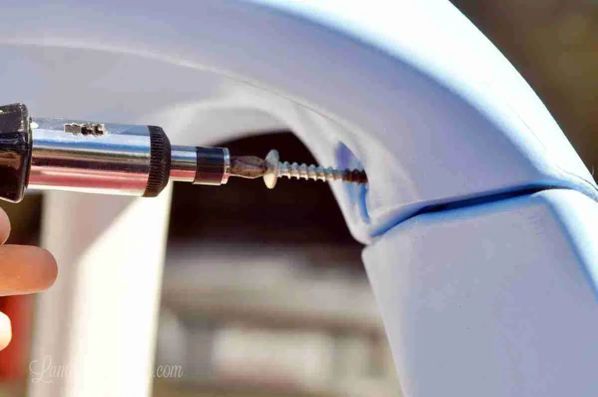 unscrewing screw at top of cozy coupe ceiling.