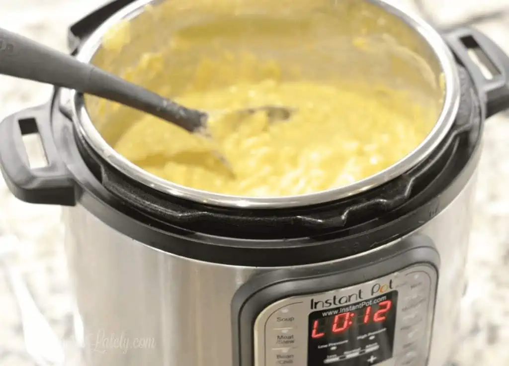 mac and cheese being stirred in an instant pot.
