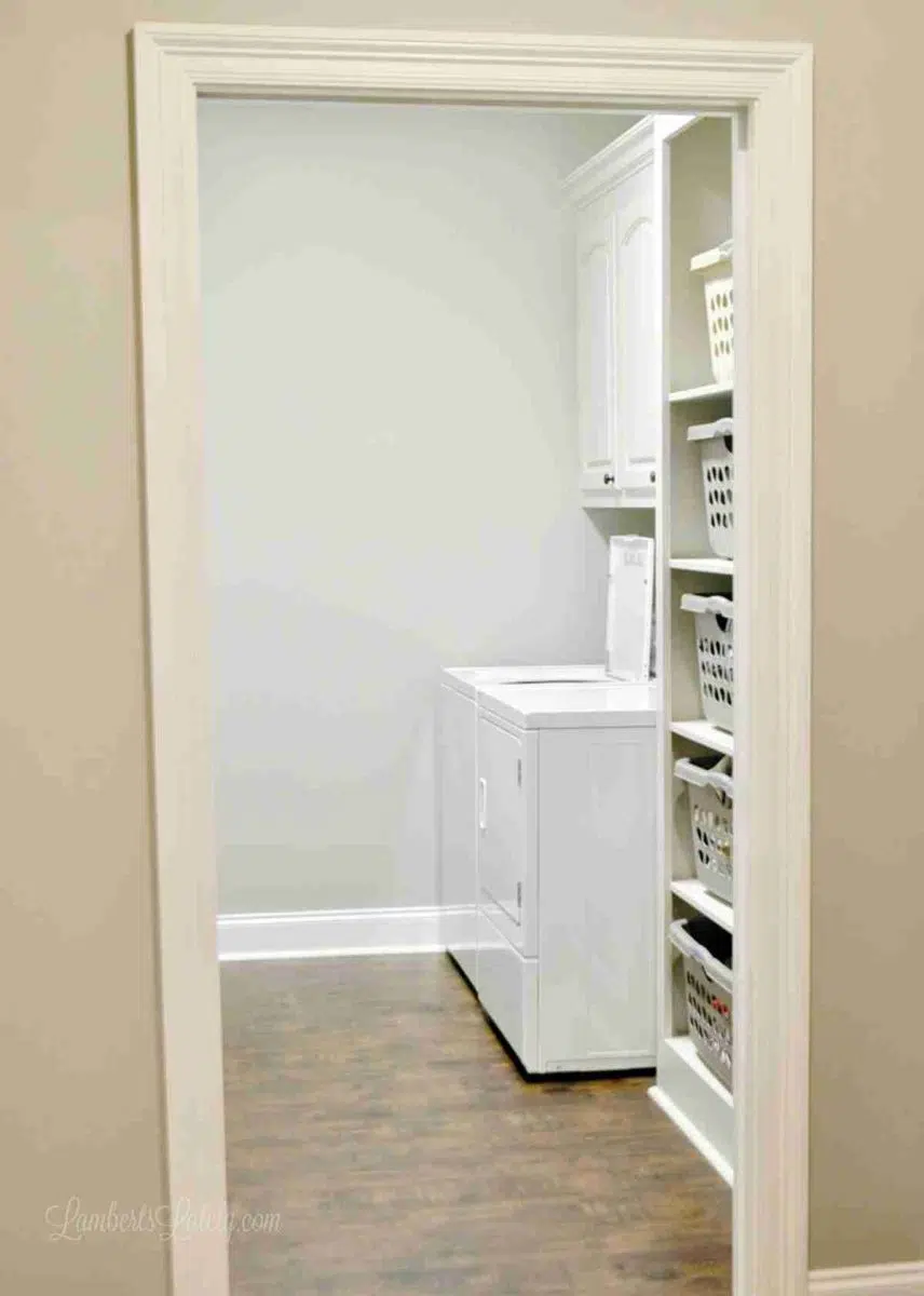 looking into a laundry room with washer and dryer, stacking basket cabinet.