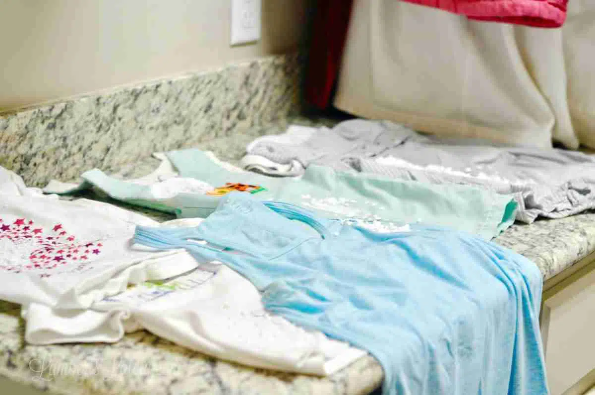 clothes covered in oxiclean paste, laid out on a laundry room counter.