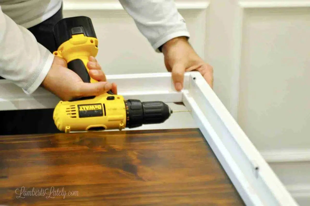 drilling a pilot hole in the plantation shutter frame.