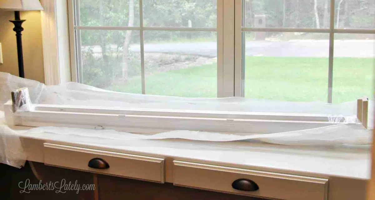 plantation shutter frame on a desk in front of an empty window.