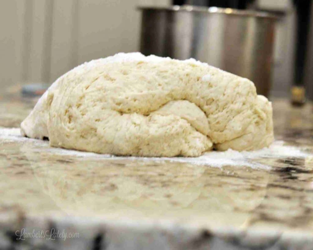Unrolled cinnamon roll dough on a floured surface ready for baking.