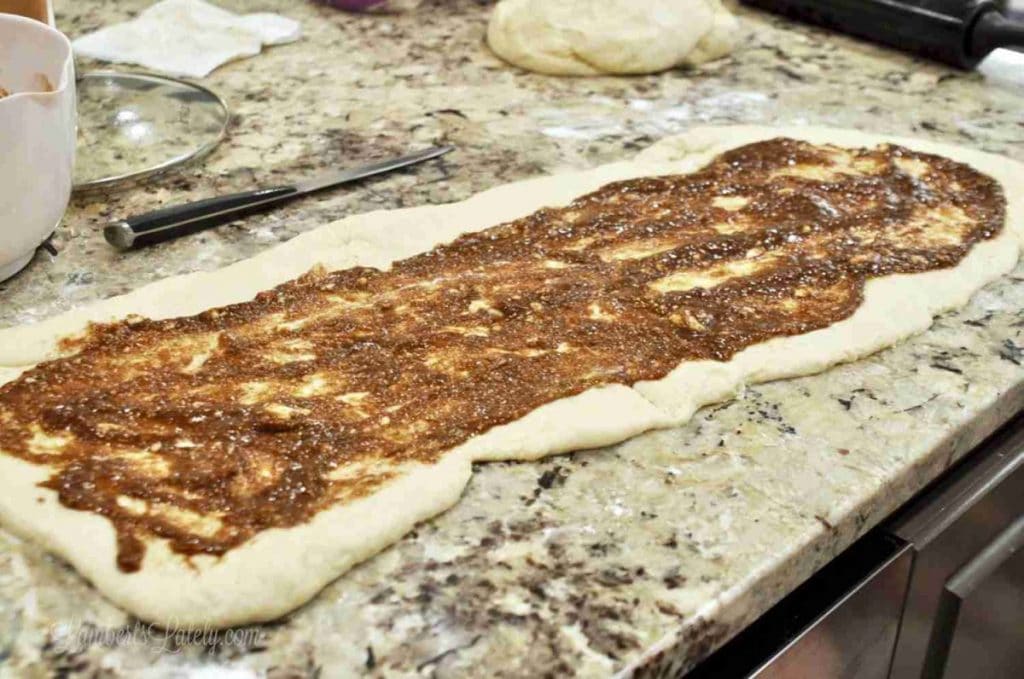 filling spread on cinnamon roll dough.