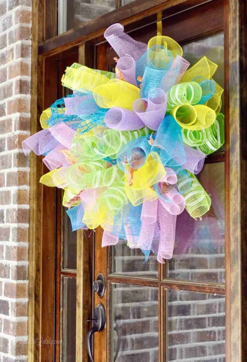 colorful deco mesh wreath hanging on a front door.