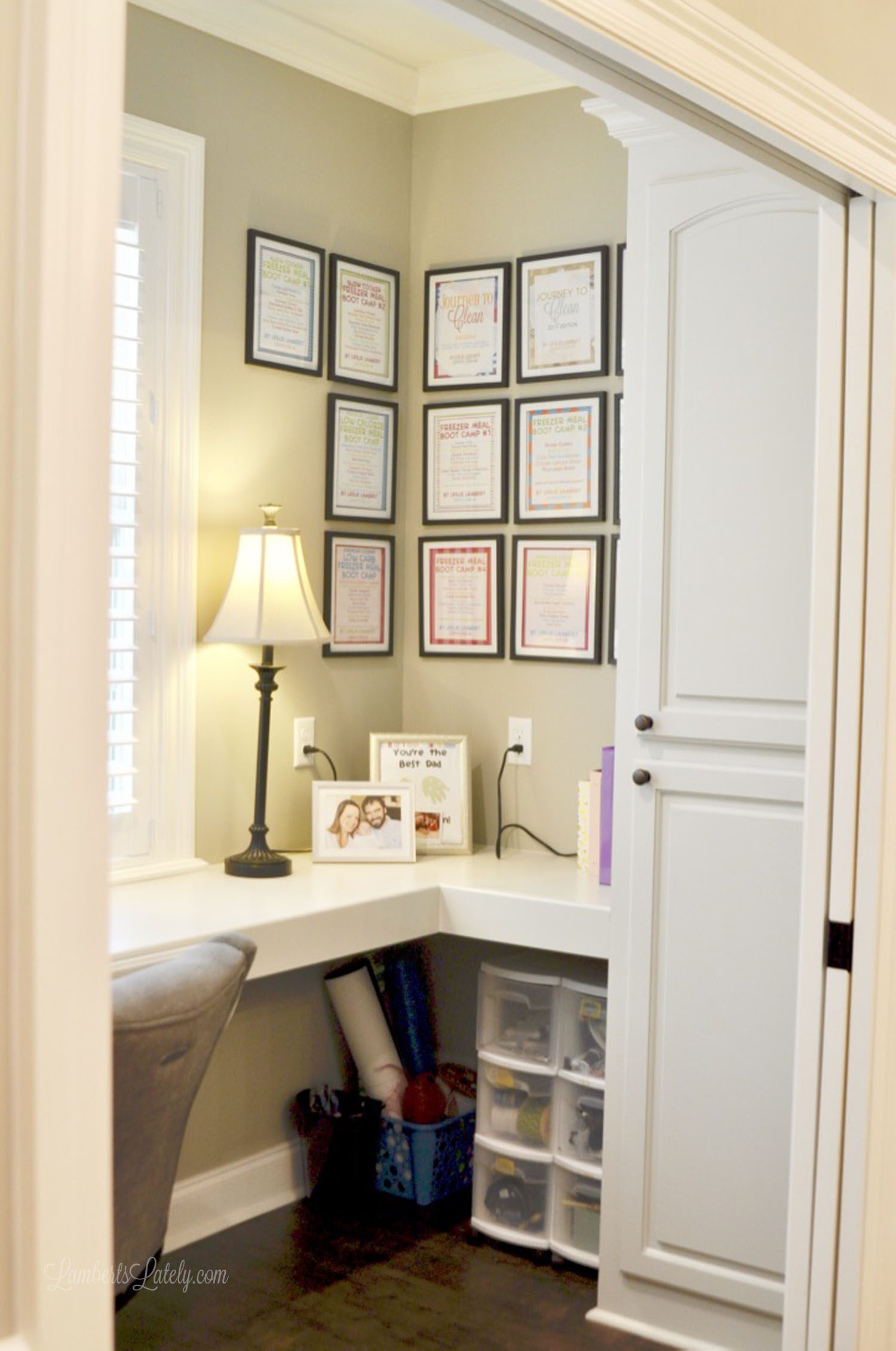 view inside of home office with framed book covers on wall.