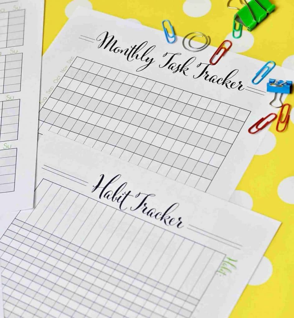 pile of habit trackers on a yellow polka dot background