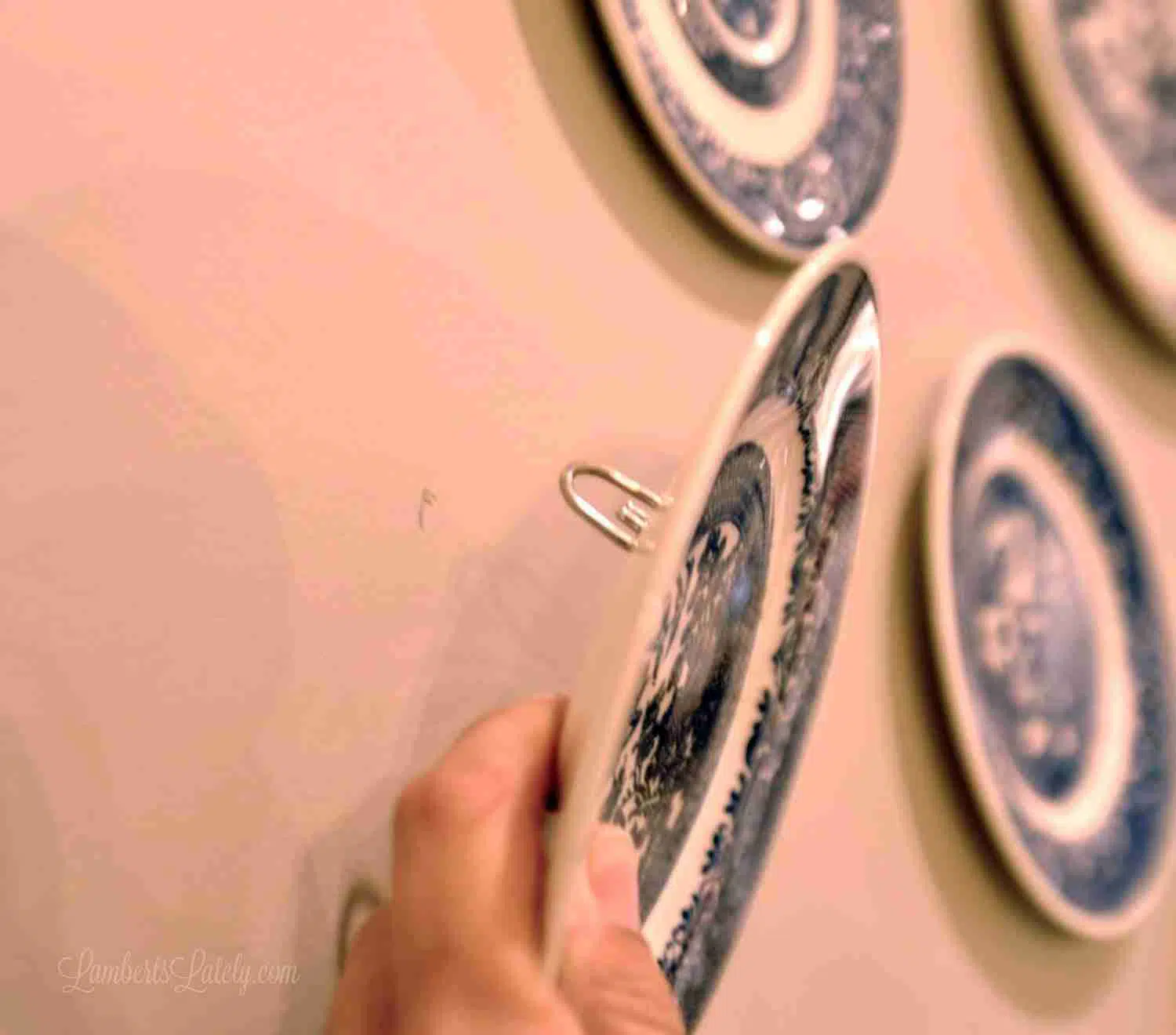 placing a plate on a nail in a wall.