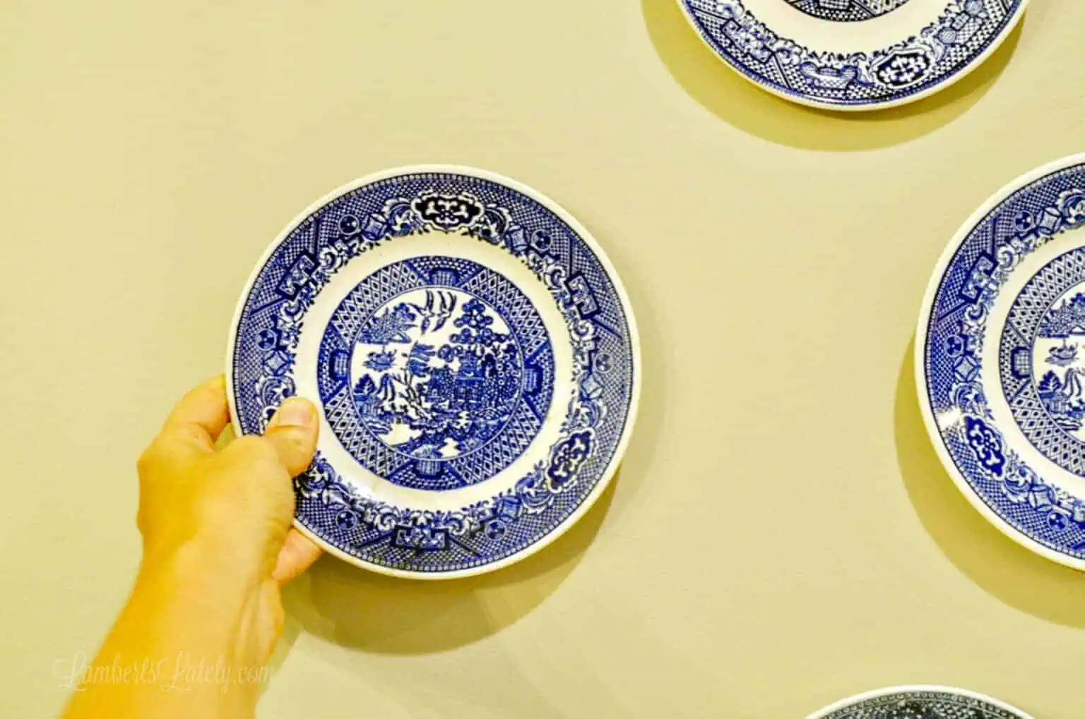 holding a plate up to the wall.