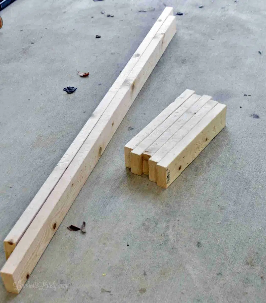 organized cut stacks of 2x4" wood on a garage floor.