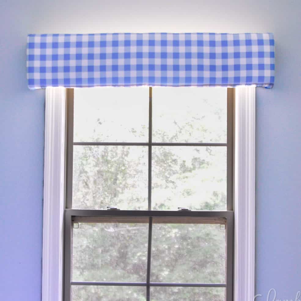 blue gingham cornice board hung above a window.