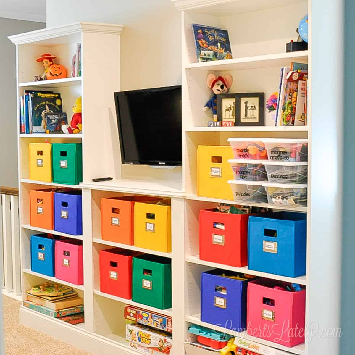 ikea billy bookcase built-ins with colorful bins in a playroom.