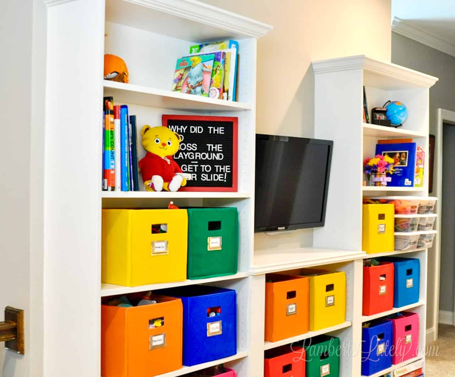 ikea billy bookcase built-ins with colorful bins in a playroom.