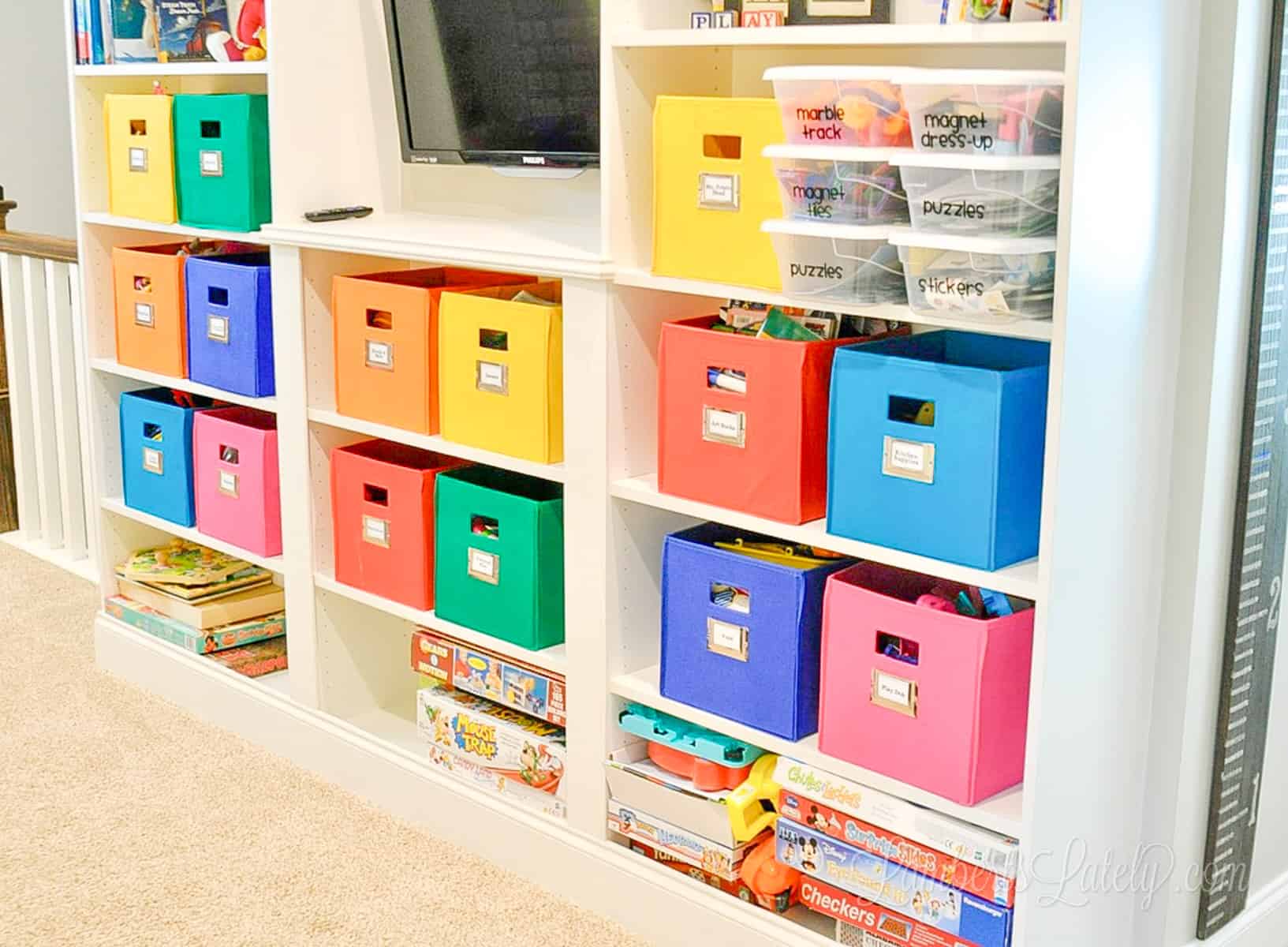 ikea billy bookcase built-ins with colorful bins in a playroom.