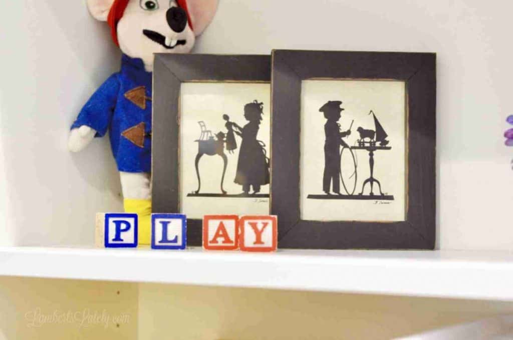 letter blocks, art, stuffed animal on a white shelf.