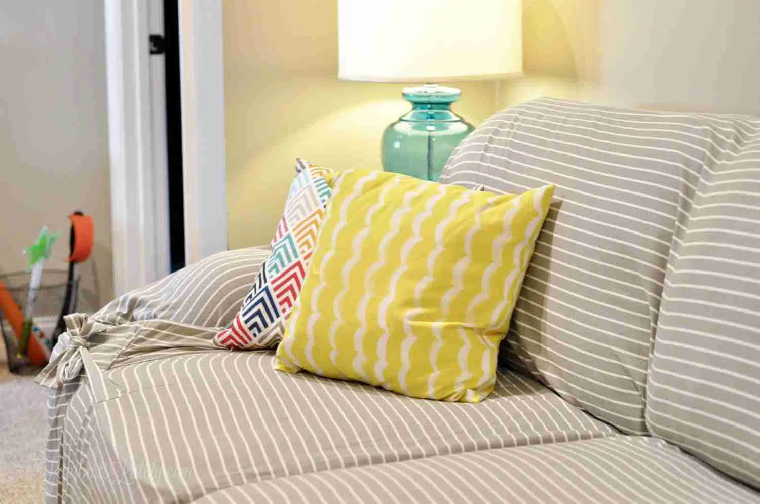 yellow pillow on a gray striped couch.