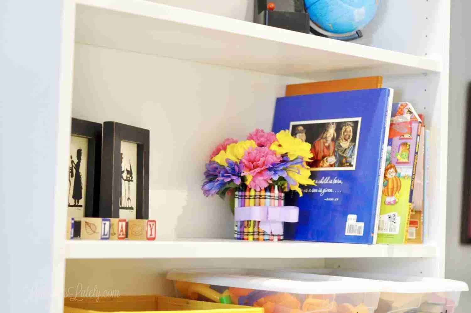 flowers, books on a white shelf.