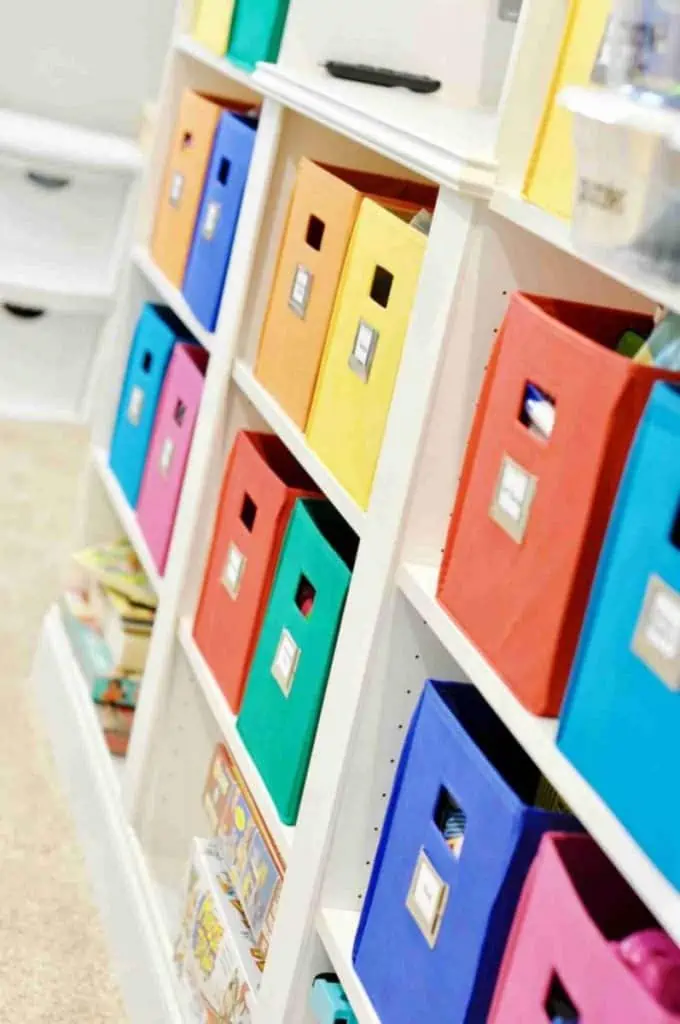 brightly colored bins on a white shelf.