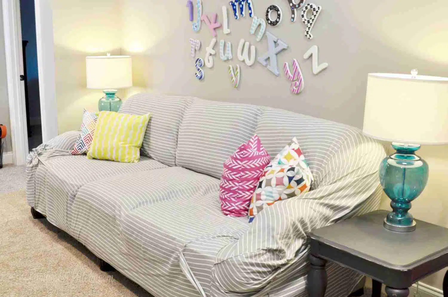 gray striped couch with brightly colored pillows.