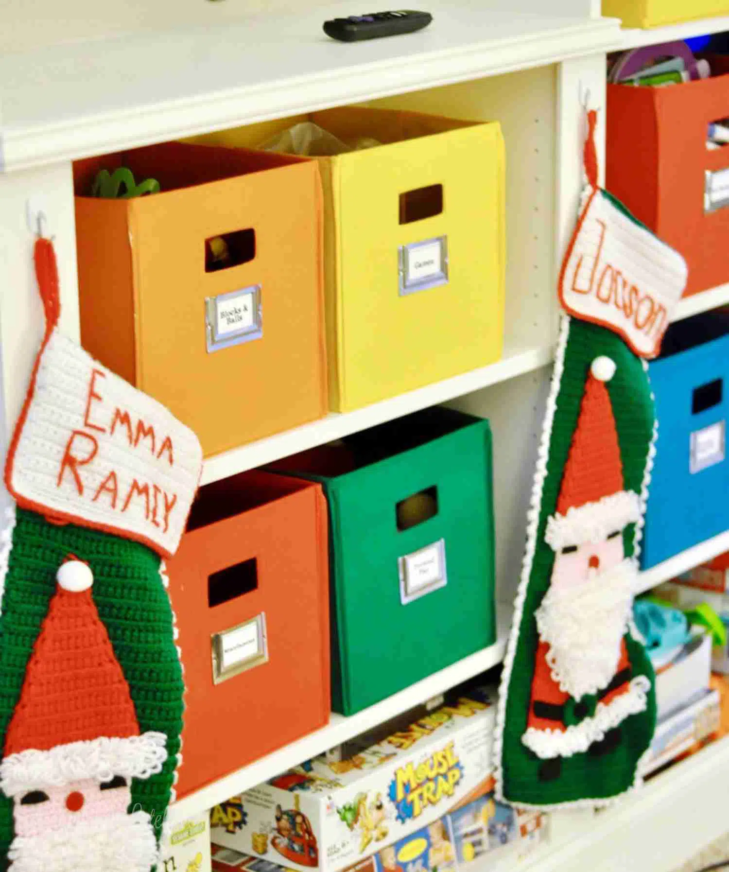 colorful bins on white shelves, with stockings hanging.
