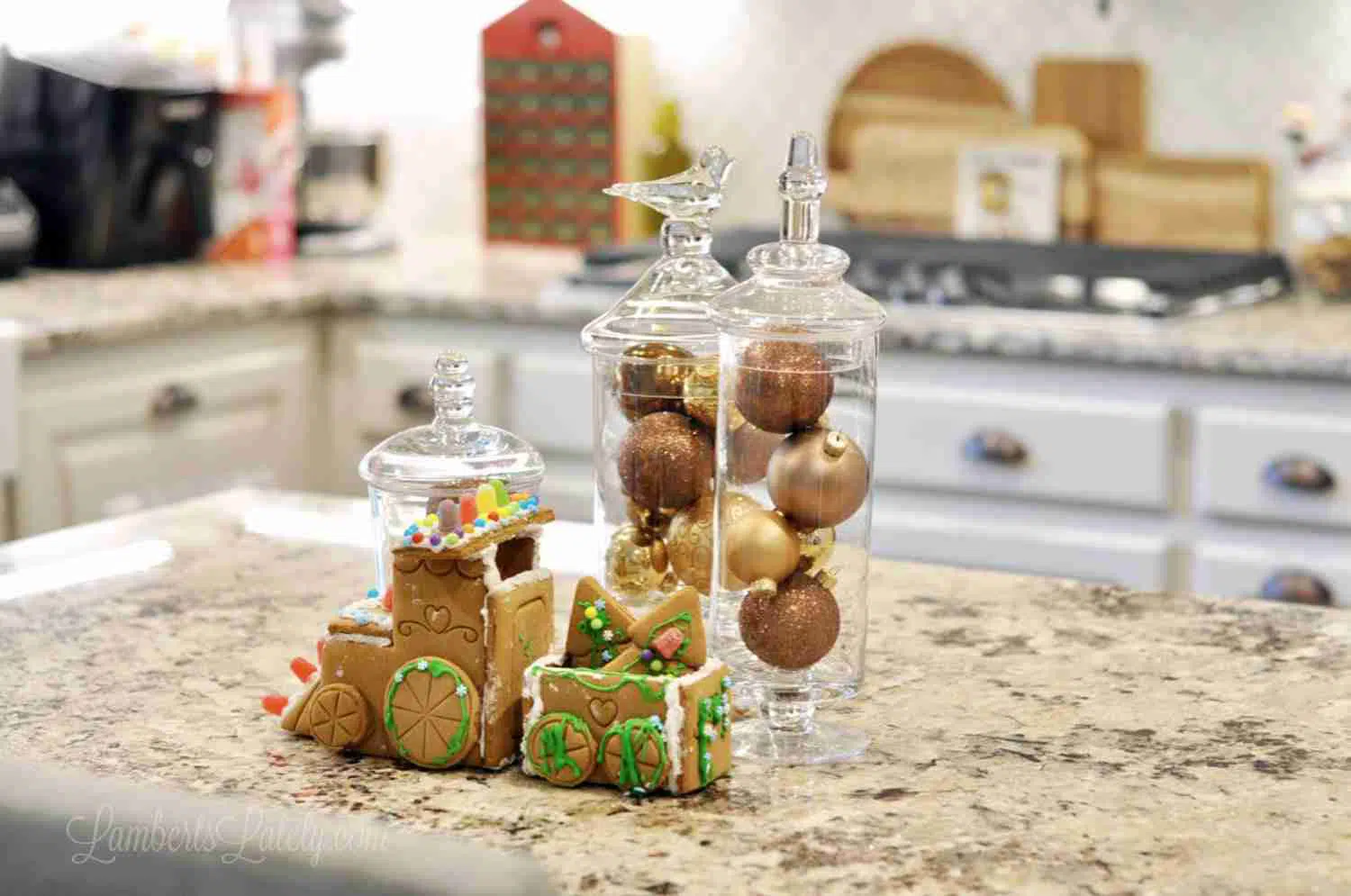 ornaments in glass jars, gingerbread train on a kitchen counter.