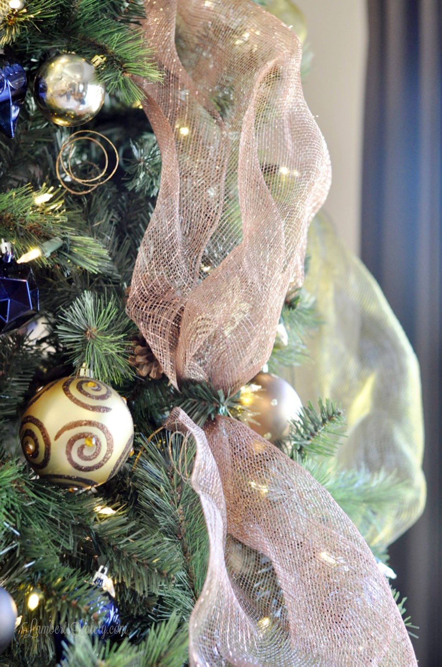 close up of ribbon and ornaments in a christmas tree.